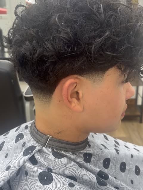 Curly hair with a clean taper, cut at our Horsforth shop